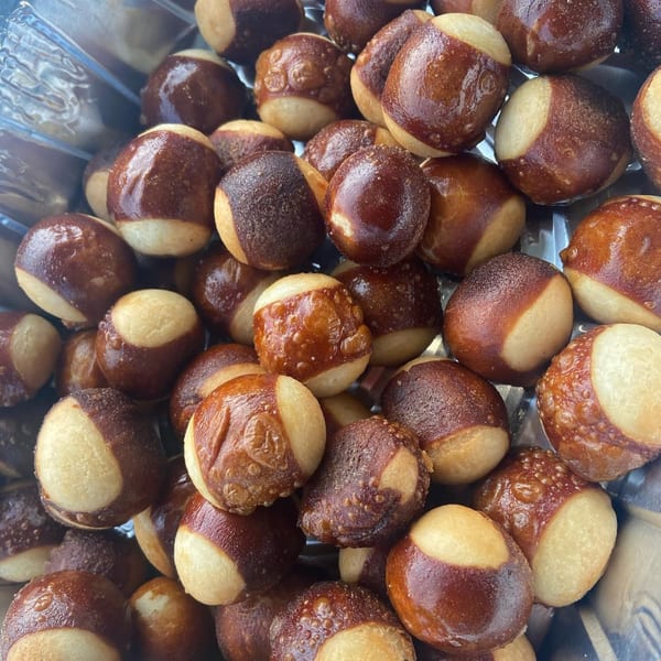 Close-up of numerous golden-brown pretzel bites with lighter undersides, piled in a container.