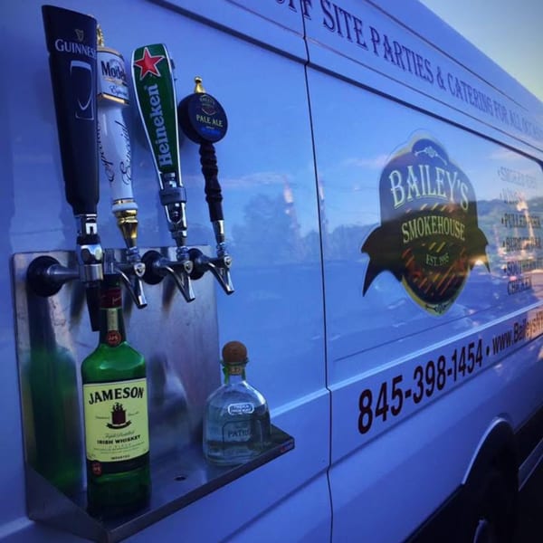 Bailey's Smokehouse catering van with beer taps, Jameson whiskey, and Patron tequila bottles.